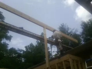 Carpenter setting a ridge beam over a new addition frame — Ice Dam Removal by Roofing Brothers in Loudon